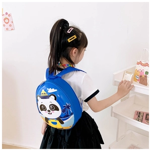 Blue hardshell kids backpack featuring a cute panda on beach, side view on model