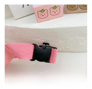 Dettaglio della fibbia in plastica nera e cinturino rosa del marsupio per bambini