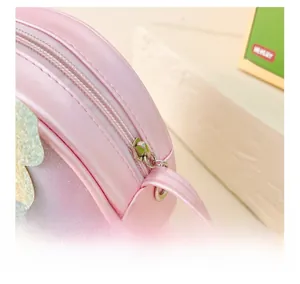 Détail de la fermeture éclair argentée et paillettes roses sur sac bandoulière pour filles