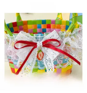 Detail of colorful rainbow woven straw basket with white lace and red strawberry bow