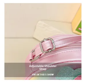 Gros plan de la bandoulière réglable avec boucle argentée sur le sac à bandoulière rose