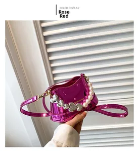 Detail of rose red metallic handbag with large pearl handle and heart metal studs
