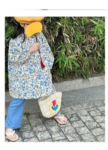 Detailed view of child's floral long-sleeve smock featuring elastic cuffs and large pockets