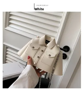 Macro view of unique jacket-shaped crossbody bag with silver chain strap and metal buttons