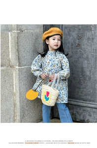 Detail of a beige woven straw handbag featuring a vibrant red tulip applique for kids
