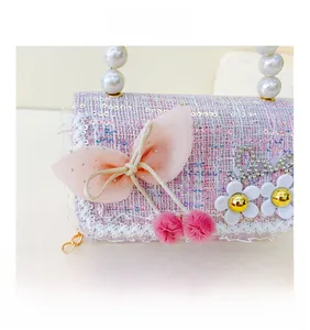 Détail du sac enfant en tweed rose avec paillettes et grand nœud en tulle doux