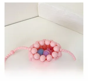 Vista dettagliata dell'interno della mini borsa di perle rosa con spazio per oggetti