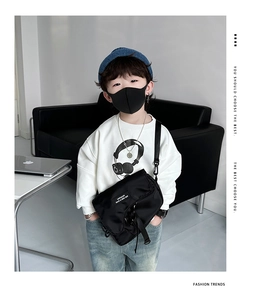 Détail de la sacoche noire en nylon pour enfant avec boucle tactique et sangle réglable