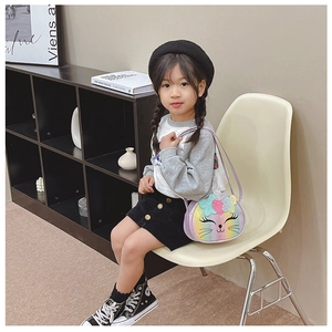 Détail du sac licorne arc-en-ciel avec oreilles 3D et broderie porté par un enfant
