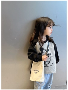 Gros plan du mini sac bandoulière en toile beige avec texte Redriver sur tenue enfant