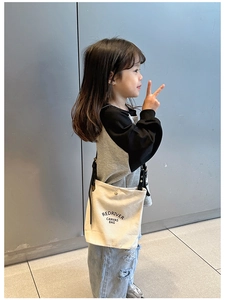 Vue détaillée d'un mini sac bandoulière en toile blanc cassé avec une sangle réglable noire