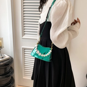 Green metallic crossbody bag with heart charms, pearl strap and gold hardware accents