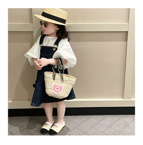 Detail of child summer outfit with woven handbag and floral crochet accents