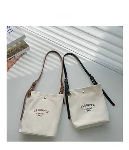 Détail du sac en toile avec bandoulière cuir, fermoir aimanté et motif Redriver
