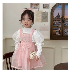 Girl's pink mesh suspender dress paired with a pearl-woven mini crossbody bag detail