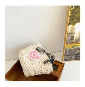 Detail of hand-woven straw tote with crochet flowers and mesh ribbon for girls