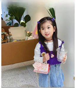 Mini sac fille en tweed rose avec poignée en perles et chaîne porté par un mannequin