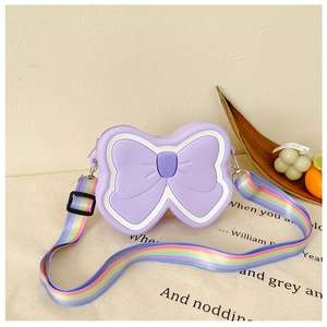 Detail of light purple silicone butterfly purse with adjustable rainbow strap on linen