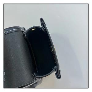 Détail du mini sac bandoulière noir avec surpiqûres blanches et compartiment intérieur