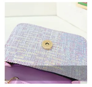 Macro shot of gold magnetic buckle and purple sequin tweed texture on children handbag