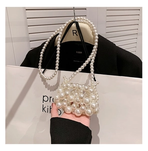 Detailed view of handmade pearlescent beaded mini bag with woven chain strap for girls