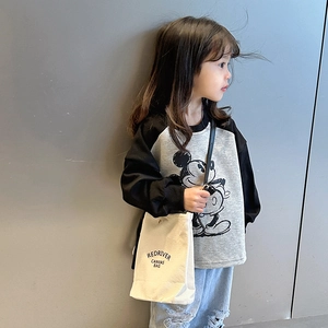Sac bandoulière en toile pour enfants, couleur beige, porté avec un look moderne