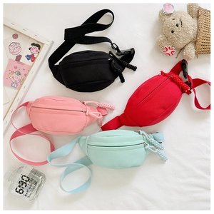 Dettaglio di marsupi per bambini in tela nei colori nero, rosso, rosa e verde con zip