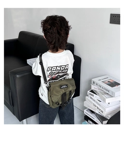 Détail de la sacoche de selle en toile vert armée pour enfants avec chaîne noire