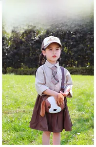 Toddler girl wearing a cute cartoon dog crossbody bag on a grassy field in the sun