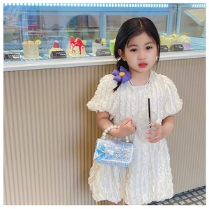 Détail du sac bleu clair pour fille avec anse en perles, nœud et chaîne dorée