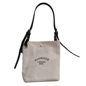 Sac à bandoulière en toile avec sangle en cuir noir et détails métalliques dorés chic