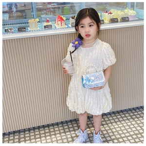 Détail d'un mini sac en tweed pour fille avec anse en perles et nœud en soie bleu