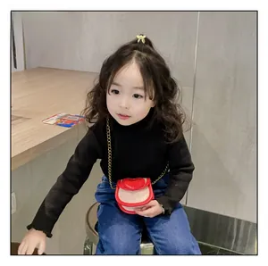 Détail du sac bandoulière rouge en forme de cœur pour fille avec chaîne dorée