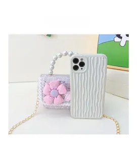 Mini floral tweed bag shown next to a smartphone for size comparison and scale