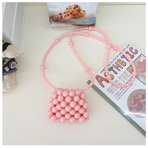 Mini borsa a tracolla con perline rosa per bambine su un tavolo in stile moderno