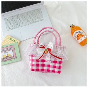 Detailed pink and white checkered woven bag with delicate lace trim and red strawberry bow