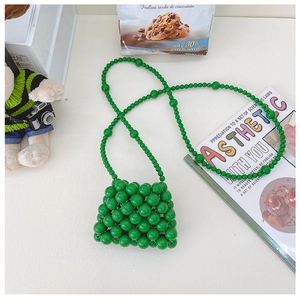 Dettaglio della mini borsa verde intrecciata a mano per bambina con tracolla chic
