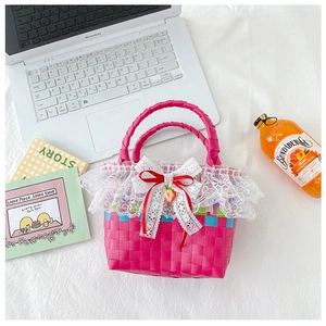 Detail of pink woven straw handbag with white lace trim and cute strawberry ornament