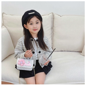 Close-up of a silver sequin girl's crossbody bag with pink floral detail and chain strap