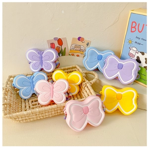 Close-up of cute cartoon silicone bow purses in macaron colors with rainbow straps