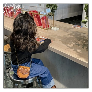 Détail du mini sac bandoulière en cuir marron avec relief cœur et chaîne dorée