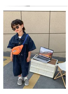 Détail du sac banane en toile orange avec écusson à lettres sur un enfant