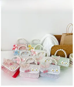 Détail de mini sacs en tweed pour filles avec poignées en perles et nœuds colorés