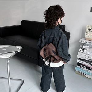 Sacoche selle en toile pour enfants avec chaîne sur une tenue streetwear en jean