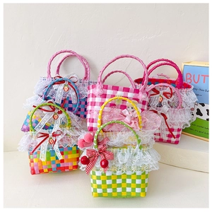 Detail of colorful hand-woven girls beach bags with lace trim and cherry charms