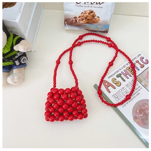 Dettaglio ravvicinato di una mini borsa a tracolla fatta a mano in perle rosse per bambine