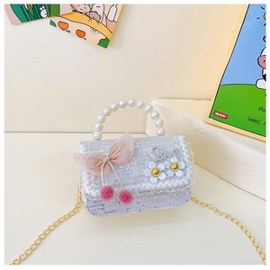 Détail du mini sac enfant en tweed avec poignée perle, nœud rose et breloque Love mauve