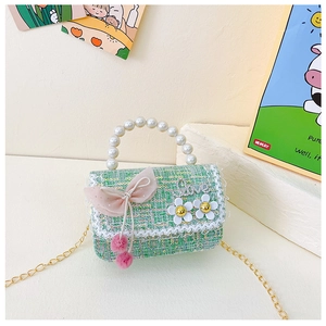 Détail d'un sac bandoulière en tweed vert avec nœud rose et poignée en perles