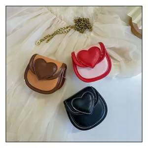 Détail de mini sacs en forme de cœur en marron, rouge et noir avec chaînes dorées