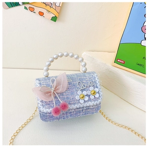 Détail d'un sac pour enfant en tweed bleu avec poignée en perles et nœud rose